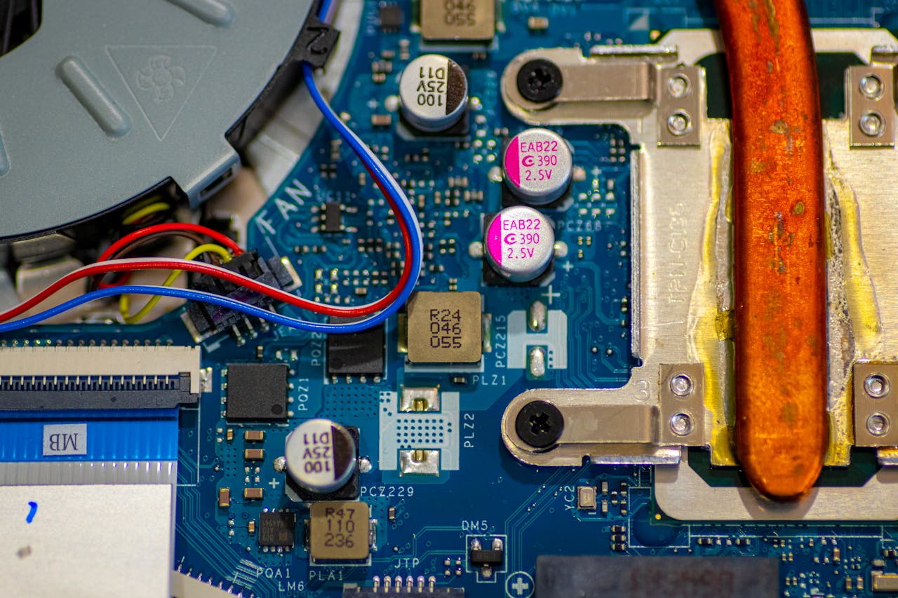 Detailed image showing circuitry and components on a computer motherboard with wires and capacitors.